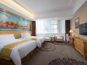 广州维也纳酒店广州白云机场空港店的酒店客房设有两张床和电视。