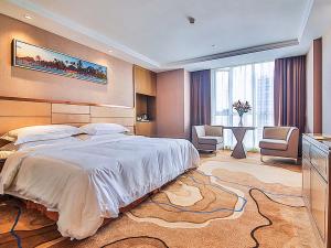 武汉维也纳国际酒店武汉街道口店的一间带大床的卧室和一间带桌子的房间
