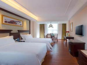 西乡维也纳酒店深圳宝安流塘店的酒店客房设有两张床和电视。