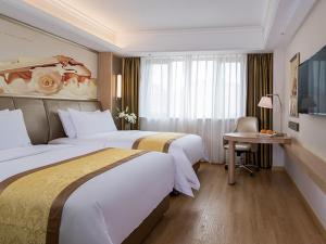 上海维也纳国际酒店 (上海金沙江路长风公园店)的酒店客房设有两张床、一张书桌和一个窗户。