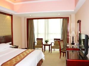 深圳维也纳酒店大学城店的酒店客房带一张床铺、一张书桌和一间卧室