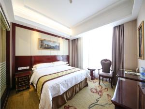 上海维也纳酒店上海虹桥会展中心店的酒店客房带一张大床和一把椅子