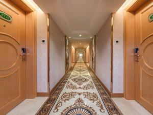 南宁维也纳酒店广西南宁高新区店的走廊设有长长的走廊,铺有瓷砖地板