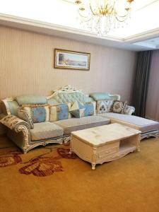 合肥维也纳酒店合肥长江东路店的客厅配有沙发和桌子
