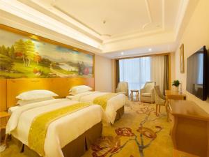 长沙维也纳国际酒店湖南长沙红星店的酒店客房设有三张床和电视。