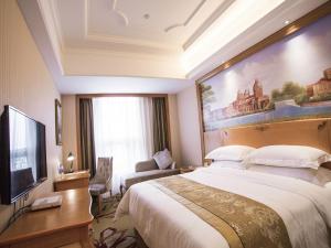 Yinzhan维也纳国际酒店贵州瓮安麒龙缤纷摩尔城店的一间酒店客房,配有一张大床和一台平面电视