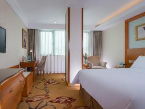 泉州维也纳酒店 (泉州西湖店)的配有一张床和一张书桌的酒店客房