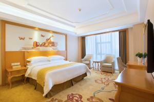 长沙维也纳国际酒店湖南长沙红星店的酒店客房设有一张大床和一张书桌。