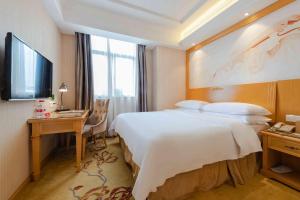 深圳维也纳3好酒店深圳西丽南科大店的酒店客房设有一张大床和一张书桌。