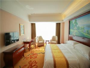 荣成维也纳国际酒店山东威海荣成店的酒店客房设有一张大床和一张书桌。