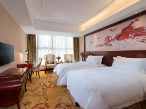 深圳维也纳酒店深圳水库新村店的酒店客房设有两张床和电视。