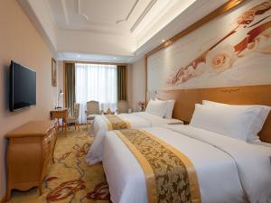 广州维也纳国际酒店广州机场新市店的酒店客房设有两张床和一台平面电视。
