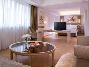 上海维也纳国际酒店 (上海金沙江路长风公园店)的大型酒店客房设有床和客厅。