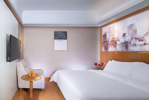 Yuanzicha维也纳3好酒店 (赣州上犹店)的卧室配有一张白色的大床和一张桌子