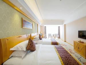 桂林维也纳酒店桂林万福广场店的酒店客房设有两张床和电视。
