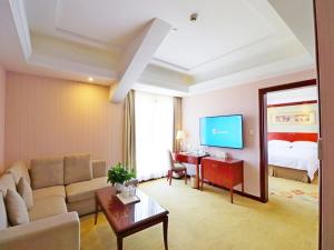 上海维也纳酒店上海虹桥国家会展纪翟路店的客厅配有沙发和1张床