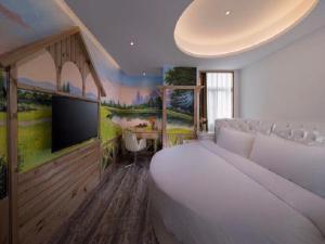 晋江维也纳国际酒店(晋江乔丹中心店)的一间卧室配有一张大床和一台电视。