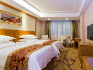 广州维也纳酒店广州松南店的酒店客房配有两张床和一张书桌