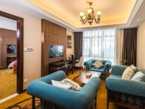 杭州维也纳国际酒店 (杭州下沙大学城店)的客厅配有蓝色的沙发和桌子
