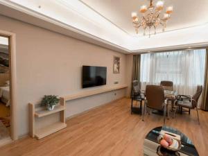Zhangjiang维也纳国际酒店 (湖南常德桃源龙八店)的客厅配有餐桌和电视