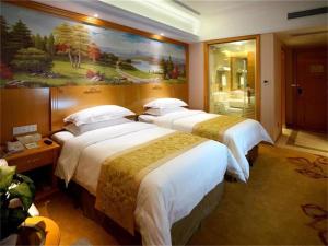 青浦维也纳酒店上海虹桥国展中心华新店的酒店客房设有三张床,墙上挂有绘画作品