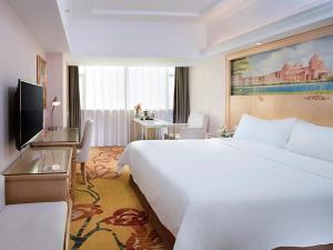 惠州维也纳智好酒店惠州大湖溪店的酒店客房设有一张白色大床和一张书桌