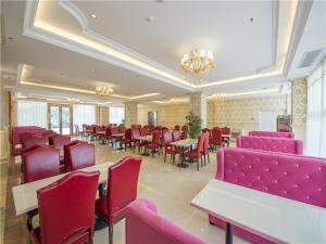桂林维也纳国际酒店桂林万达店的用餐室配有桌椅和粉红色的椅子