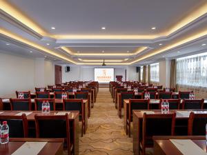 阿拉善左旗维也纳国际酒店内蒙古阿拉善店的大房间设有桌椅和屏幕