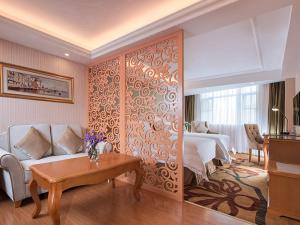 广州维也纳酒店广州天河客运站店的一间卧室配有一张床、一张沙发和一张桌子