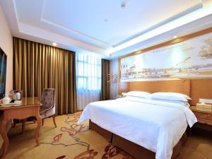 深圳维也纳智好酒店深圳坂田五和大道店的酒店客房设有一张大床和一张书桌。