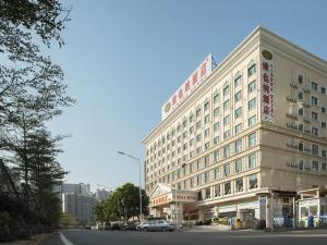 宝安维也纳酒店深圳龙华人民南路店的一座大型建筑,前面有停车位