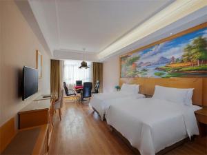惠州维也纳酒店广东惠州惠阳三和广场店的酒店客房设有两张床和一台平面电视。