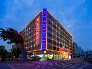 Fenghuangwei维也纳酒店深圳福永村店的一座建筑的侧面有灯