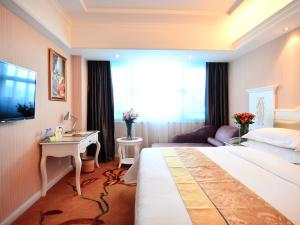 桂林维也纳酒店广西桂林站店的酒店客房设有一张大床和一张书桌。
