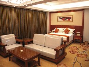平凉维也纳智好酒店崆峒大道店的酒店客房配有一张床、一张沙发和椅子。