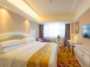 桂林维也纳酒店广西桂林站店的酒店客房设有一张大床和一张书桌。