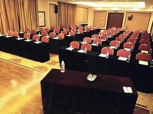 荣成维也纳国际酒店山东威海荣成店的一间会议室,配有书桌和红色椅子