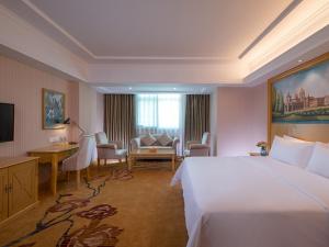 深圳维也纳酒店深圳罗芳店的酒店客房设有一张大床和一张书桌。