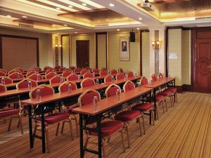 深圳维也纳酒店大学城店的一间会议室,配有书桌和红色椅子
