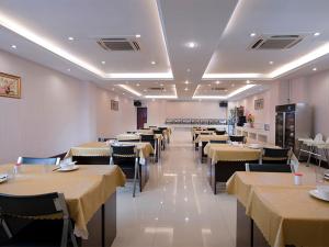 宝安维也纳酒店深圳沙井中心路店的用餐室配有桌椅和黄色桌布