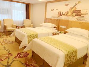 深圳维也纳酒店深圳东门老街店的酒店客房设有两张床和墙上的吉他