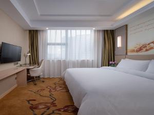 赣州维也纳酒店 (江西赣州火车站店)的酒店客房配有一张床、一张书桌和一台电视。
