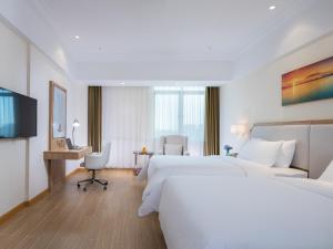 Wanzhi维也纳3好酒店(芜湖县汽车站店)的酒店客房配有两张床和一张书桌