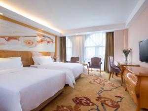 深圳维也纳智好酒店深圳坂田五和大道店的酒店客房设有两张床和一台平面电视。