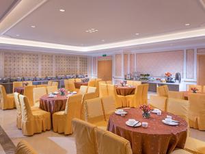 宝安维也纳酒店深圳福永地铁站店的用餐室配有桌子和黄色椅子