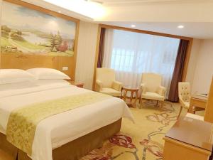 深圳维也纳酒店深圳东门老街店的酒店客房带一张床、一张桌子和椅子