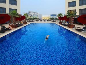 深圳维也纳酒店深圳会展中心店的在大型蓝色游泳池游泳的人