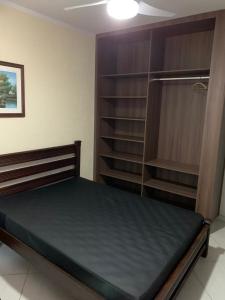 朱奎Casa de Temporada Juquehy的一间卧室设有一张床和一个书架