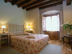 科维达Posada de Peredo y Villa的一间卧室设有一张床和一个窗口