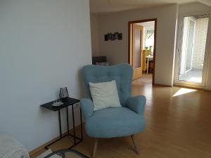帕德博恩Ferienwohnung am Lippesee的客厅配有蓝色椅子和桌子
